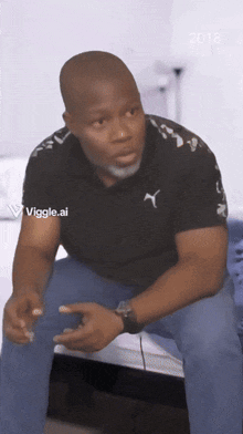 a man wearing a black shirt with a puma logo on the front