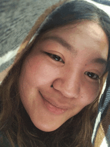 a close up of a woman 's face with a blanket on her head