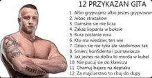 a man with a tattoo on his arm stands with his arms crossed in front of a sign that says " 12 przykazan gita "