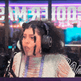 a woman wearing headphones stands in front of a sign that says pam