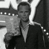a man in a suit holds a card that says happy holidays lucky 38