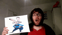 a man in glasses holds up a picture of judy hopps