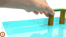 a person is playing with a bridge made of magnets in a pool of water