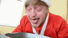 a man wearing a santa hat and a red shirt with a spider man on it is vomiting