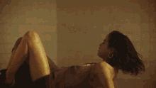 a woman in a brown dress is laying down with her legs crossed