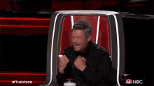 a man sitting in a chair with a nbc logo in the corner