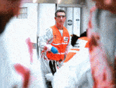 a man wearing a vest that says ' emergency ' on it