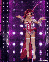 a drag queen in a red and silver costume is dancing on a stage