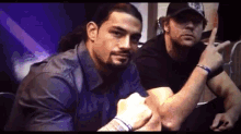 two men are posing for a picture and one of them has a tattoo on his elbow
