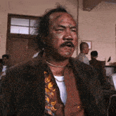 a man with a mustache is wearing a jacket and a shirt