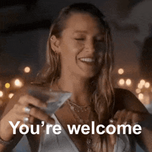 a woman is holding a martini glass and smiling with the words you 're welcome below her