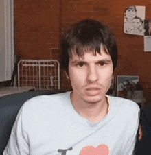 a man is wearing a white shirt with a heart on it
