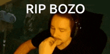 a man wearing headphones is sitting in a chair with his eyes closed and the words rip bozo written above him .