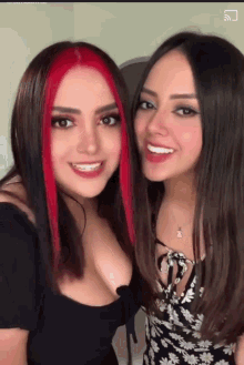 two women are posing for a picture and one of them has red hair