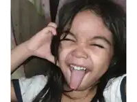 a little girl making a funny face with her tongue hanging out