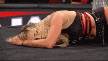 a woman laying on the ground with her head on her hands