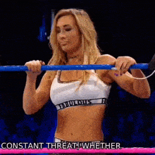 a woman is holding a bar in a wrestling ring and says constant threat whether .