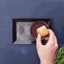 a person is dipping a piece of bread in a bowl of chocolate sauce