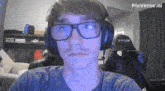a man wearing glasses and headphones with the word s-racer on the back of his chair