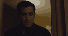 a man in a black shirt is looking out a doorway
