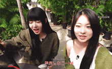 two girls are standing next to each other and one of them has a foreign language written on her face