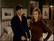 a man and a woman standing next to each other in a bedroom