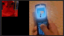 a person is holding a flip phone in their hand with a picture of a person on the screen .