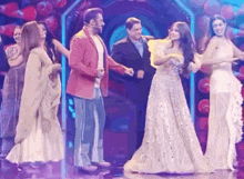 a group of people are standing on a stage and talking to each other .