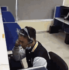a man wearing headphones is sitting at a desk in an office