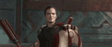 a man is holding a spear and a shield with the letter g on it