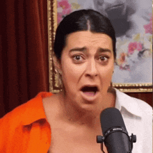 a woman making a funny face in front of a microphone