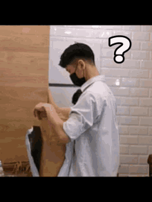 a man wearing a mask is standing in front of a wooden wall with a question mark on his forehead .