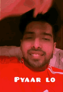 a man in a red shirt is smiling with the words pyaar lo below him