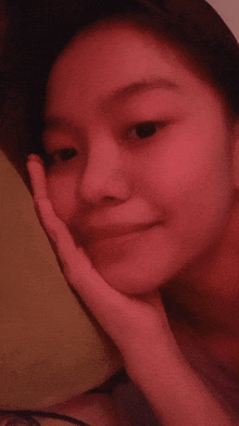 a close up of a woman 's face with her hand on it