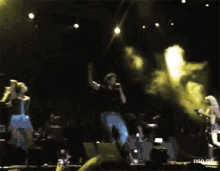 a blurry photo of a group of people dancing on a stage with rbd.gif below them
