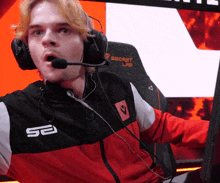 a man wearing headphones and a jacket with the letter s on it