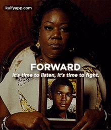 a woman is holding a picture of a young boy in a frame .