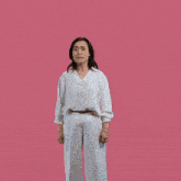 a woman in a white shirt and white pants is dancing