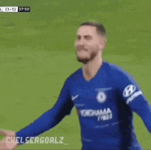 a soccer player in a blue jersey is celebrating a goal during a soccer game .