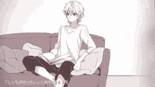 a man is sitting on a couch reading a book