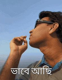 a man wearing sunglasses looks up at the sky with a foreign language written on the bottom