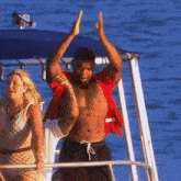 a man in a red shirt is giving a high five to a woman on a boat