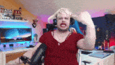 a man wearing a wig and headphones is sitting in front of a computer monitor