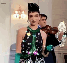 a woman in a black dress is standing next to a man playing a violin .