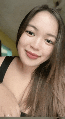a woman with long hair is smiling and wearing a ring