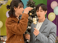 a couple of men are standing next to each other eating marshmallows .