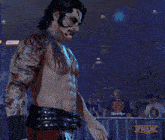 a man with a tattoo on his chest is standing in front of a crowd with a tnlw logo in the corner