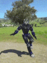 a person in a robot costume is standing in a field with a tree in the background
