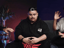 a man sitting on a couch with a loading screen on his head