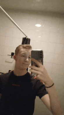 a young man taking a picture of himself in the mirror